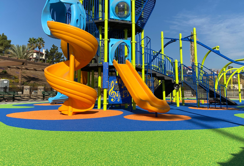 colorful poured in place surfacing underneath a large playground